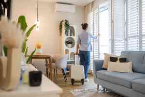 Frau öffnet Fenster in Wohnung